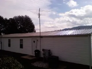 New metal roof on a single wide mobile home with a TV antenna in Tracy